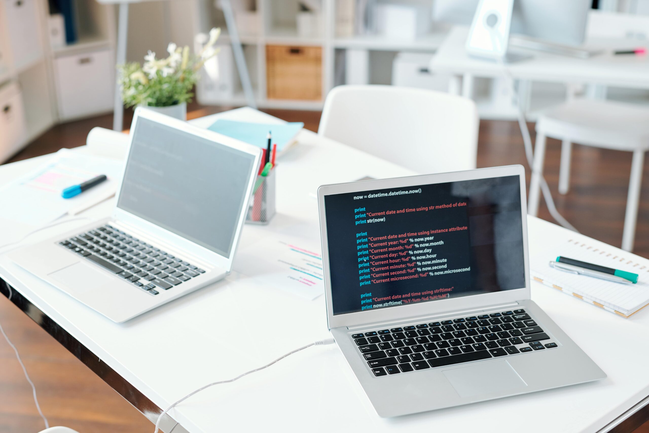 Two laptops on desk with online data on display